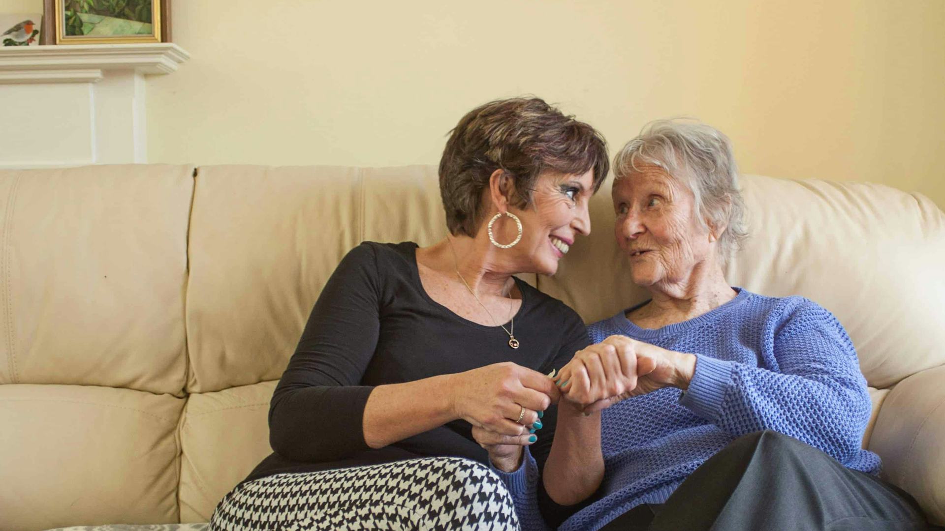 Elderly lady and her carer sat on the sofa together