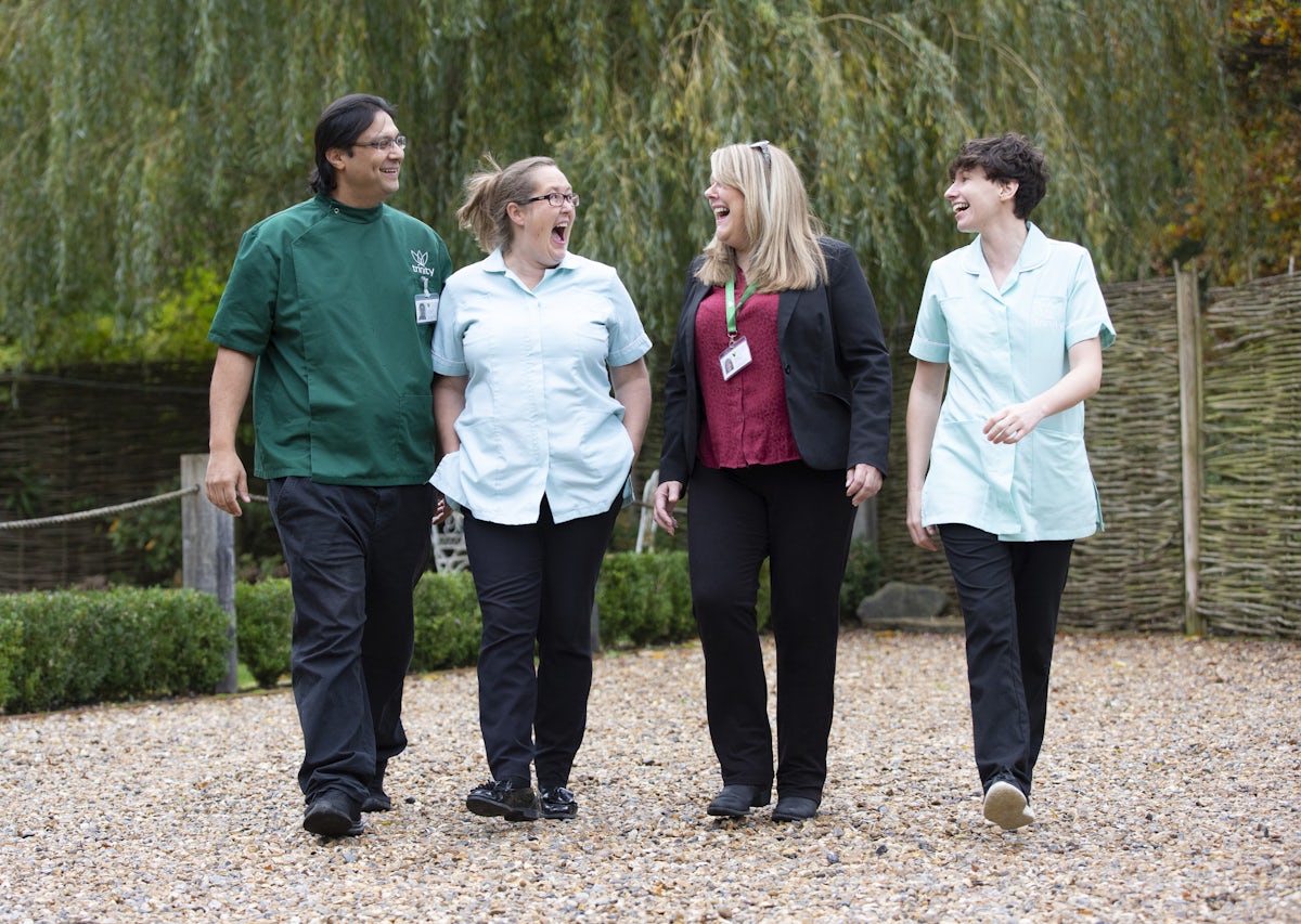 Three carers and a care manager walking together