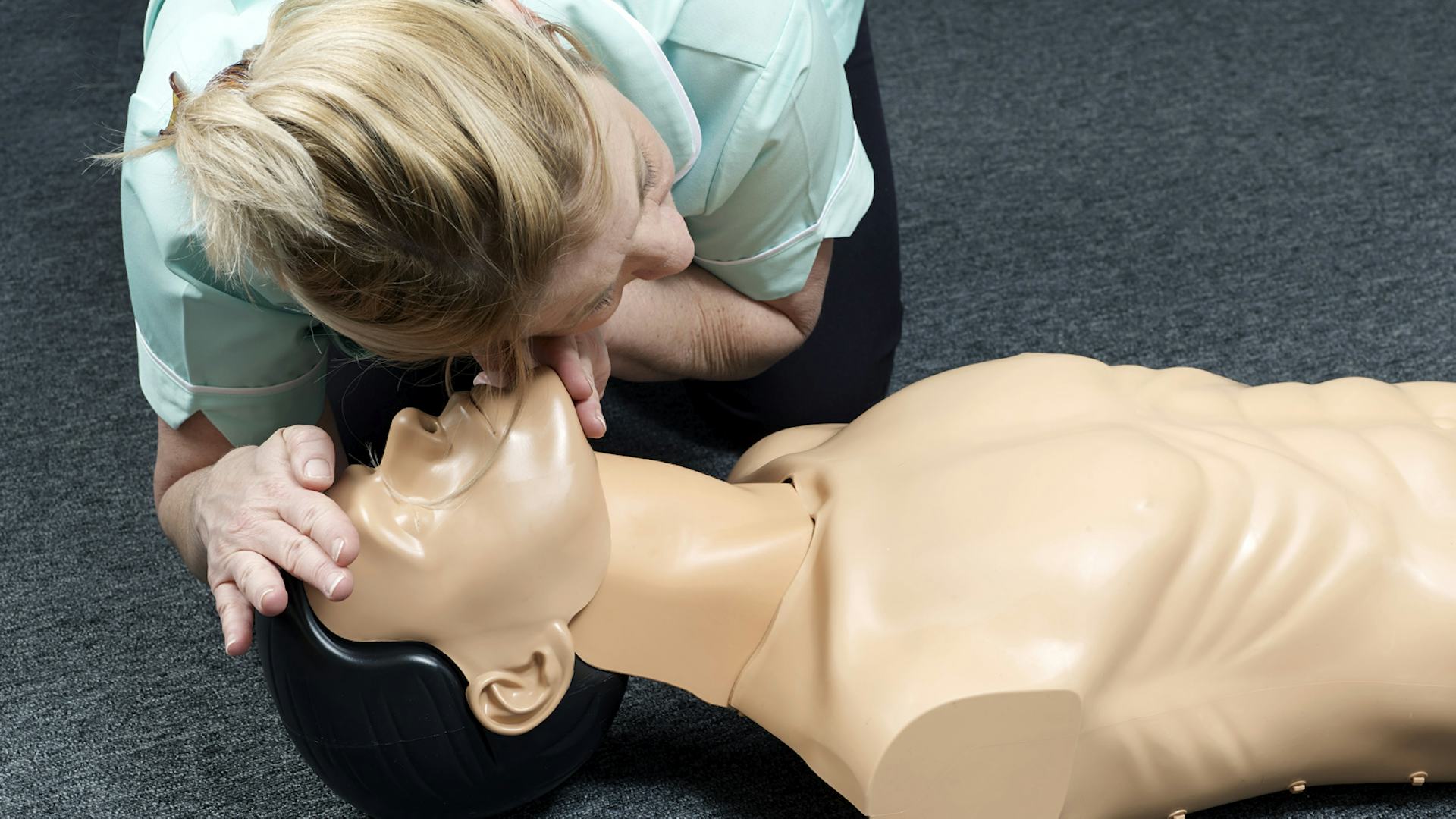 Carer checking for breathing during a first aid training with the resus CPR Manikin