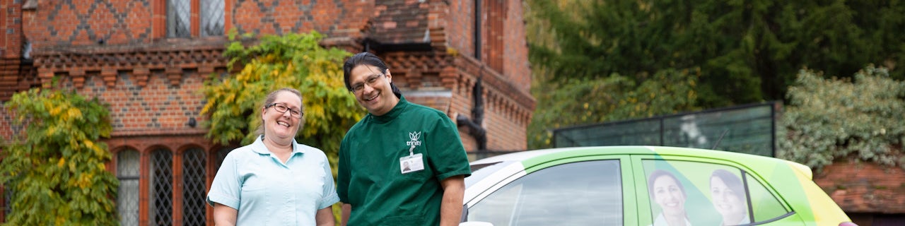 Two carers standing next to a Trinity Homecare Branded Car