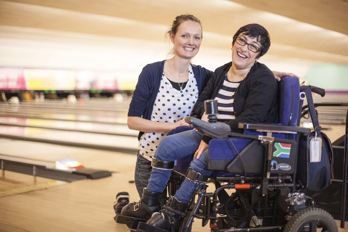 Carer with a lady with Cerebral Palsy in her motorised chair