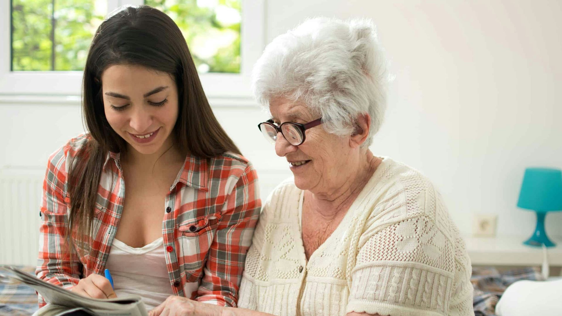 Elderly Lady Completing A Crossword