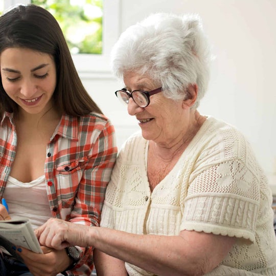 Elderly Lady Completing A Crossword