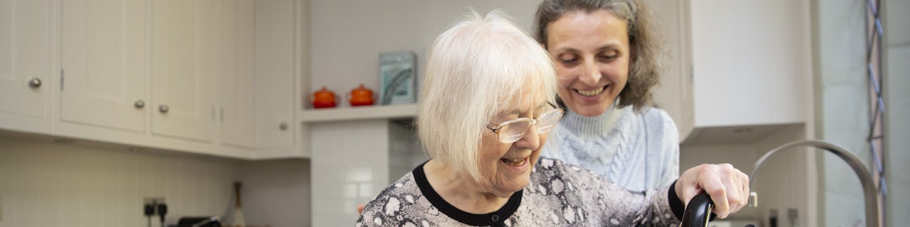 Elderly Lady with Kettle being supported by her Carer