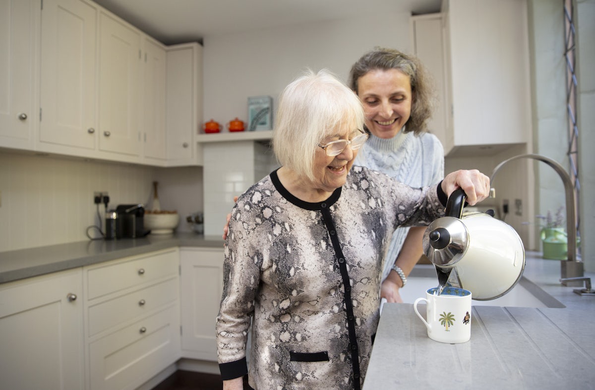 Elderly Lady with Kettle being supported by her Carer