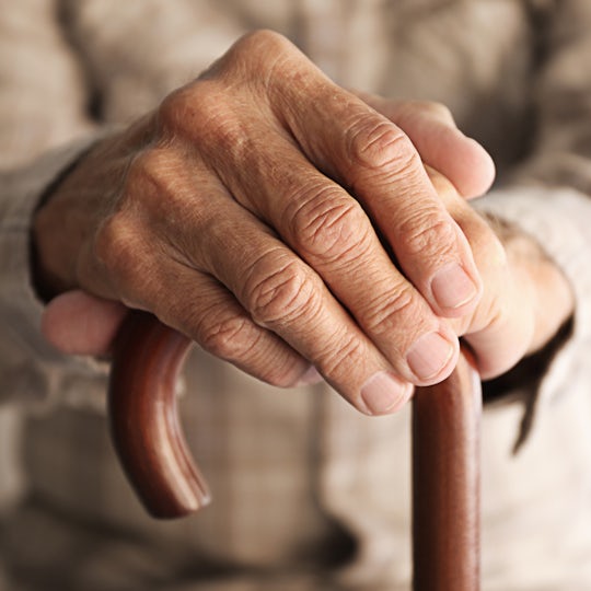 Old man hands on walking stick