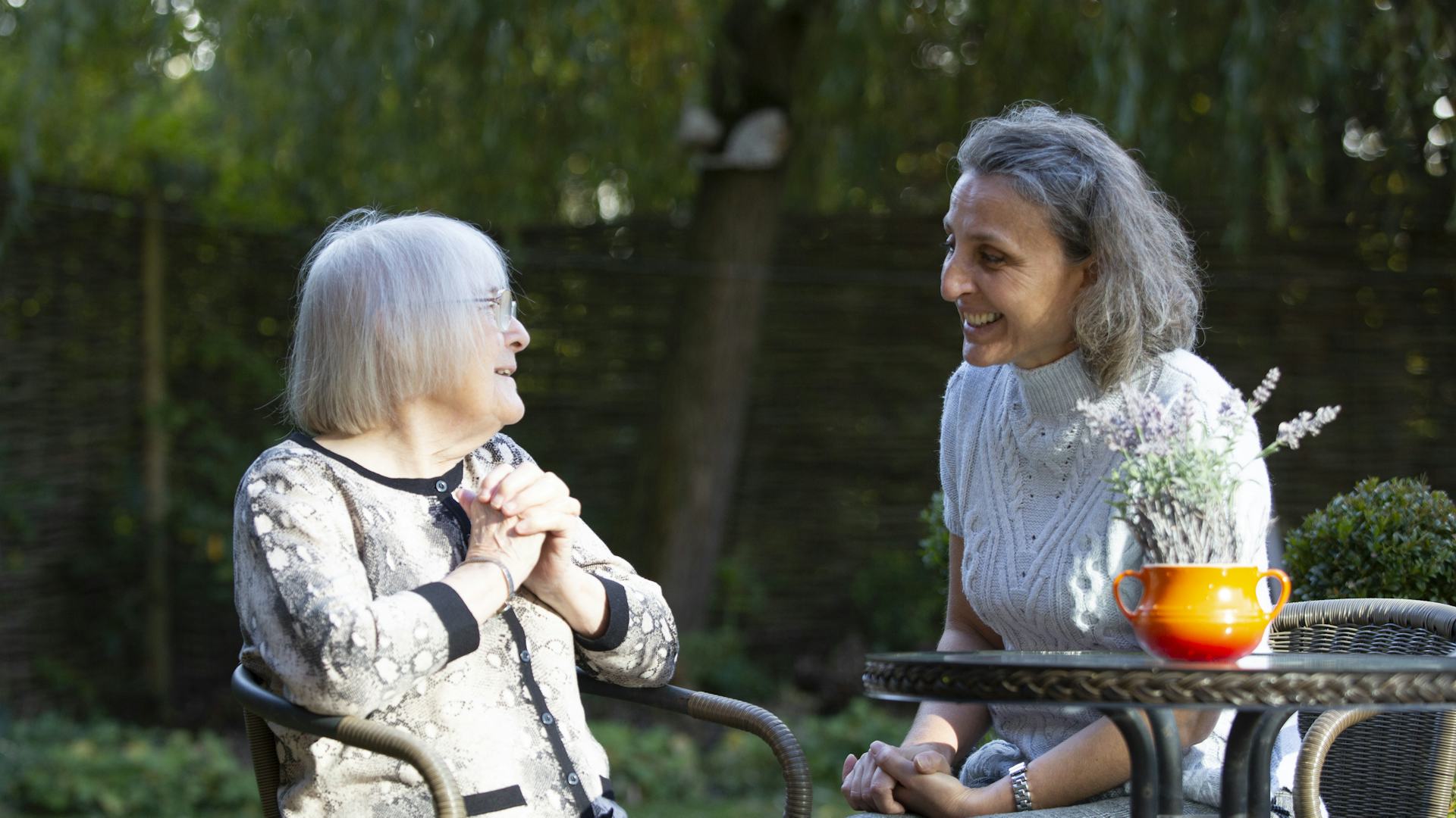 Carer and elderly lady sitting in the garden