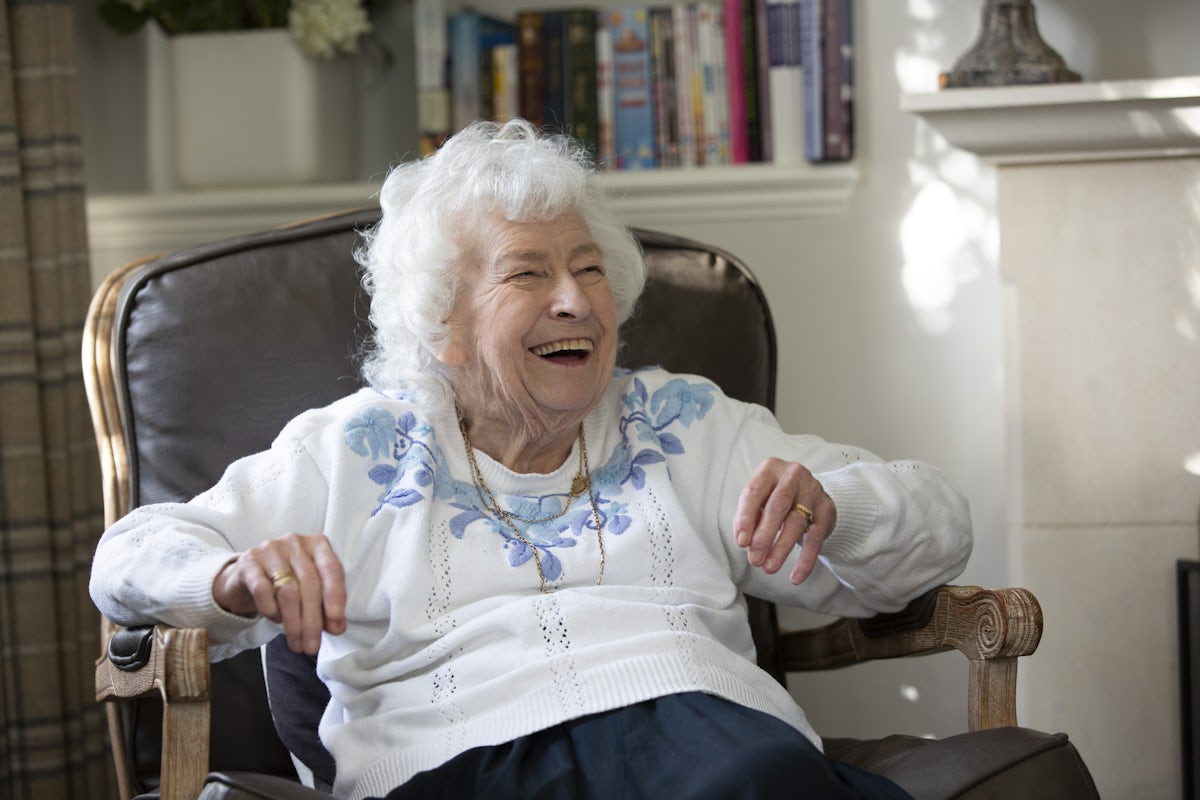 Elderly Lady sat in a chair laughing