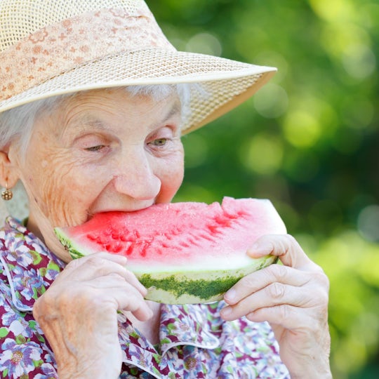 Elderly woman eating a watermelon in the summer